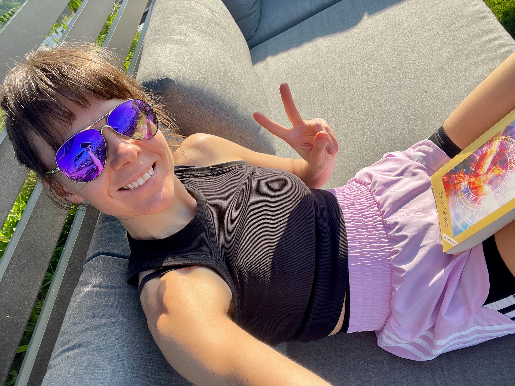 Rozalia relaxing outdoors while reading an astrology and psychology book